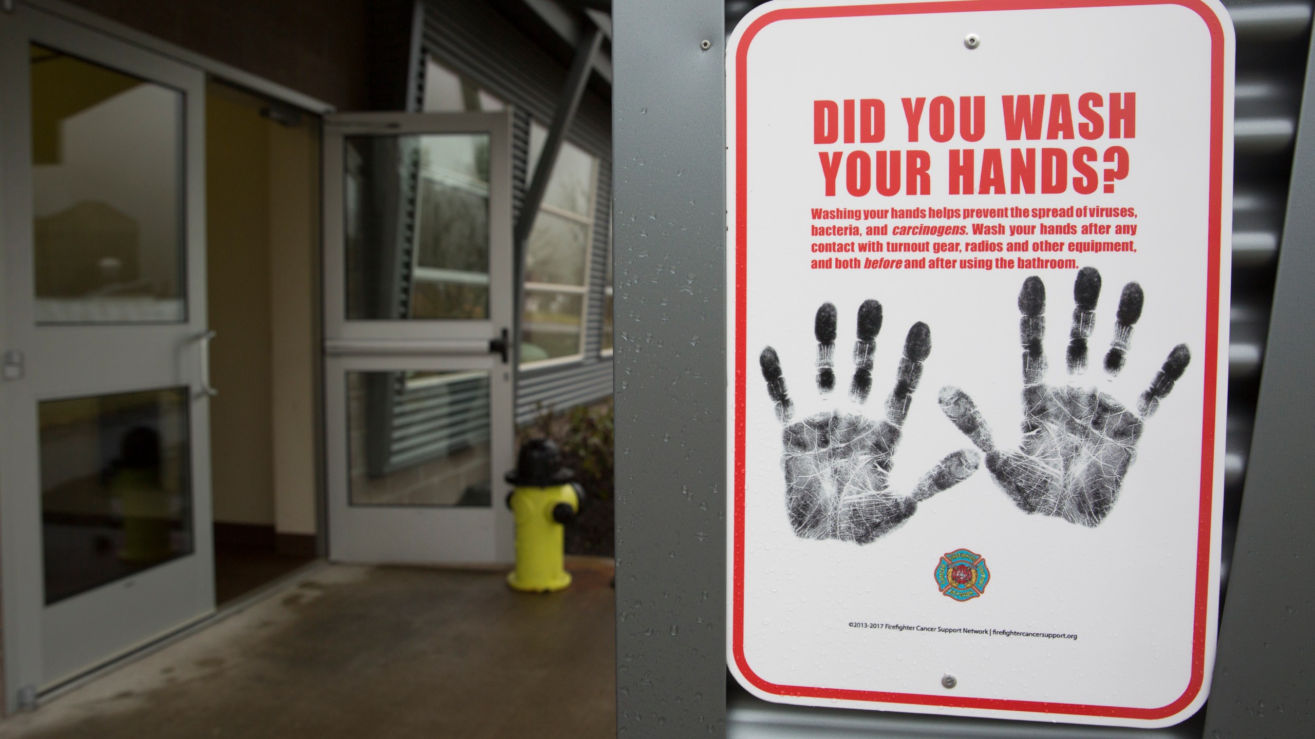 A sign reminding people to wash their hands is pictured outside a dormitory at the Washington State Patrol Fire Training Academy which has been designated as a 2019 novel coronavirus quarantine site for travelers from Hubei Province, China. (Photo by JASON REDMOND/AFP via Getty Images)