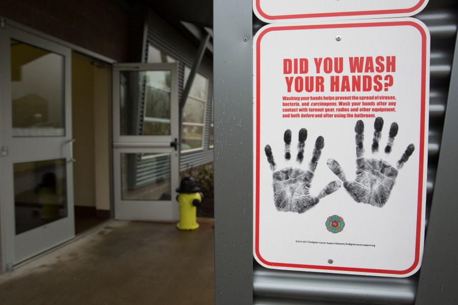 A sign reminding people to wash their hands is pictured outside a dormitory at the Washington State Patrol Fire Training Academy which has been designated as a 2019 novel coronavirus quarantine site for travelers from Hubei Province, China. (Photo by JASON REDMOND/AFP via Getty Images)