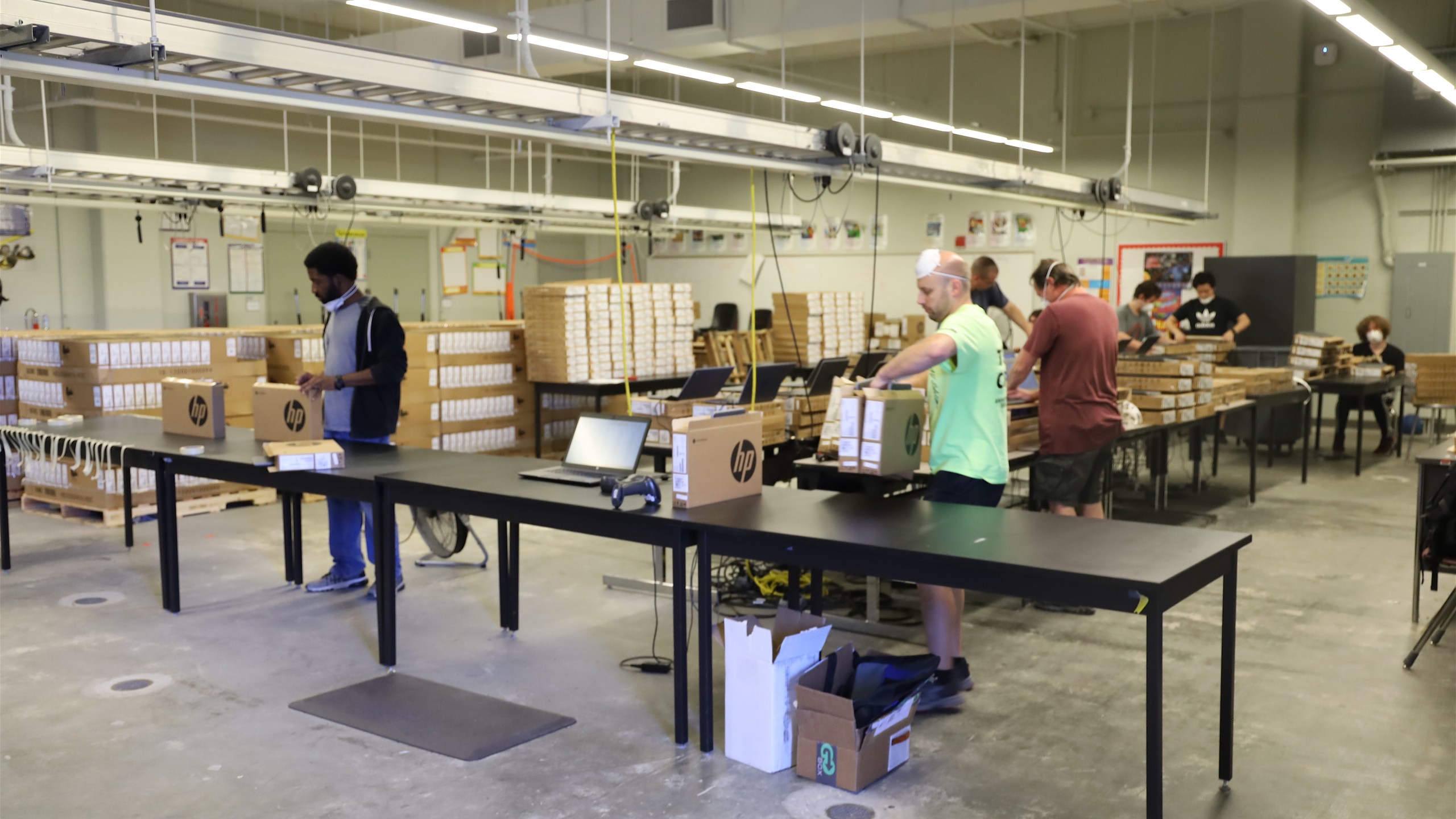 NOLA PS Workers prepare chromebooks for distribution.