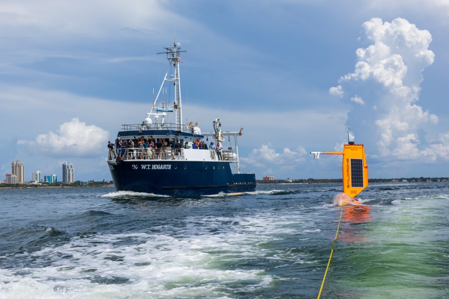 Media and others watch from the deck of the University of South Florida's R/V W.T. Hogarth as a hurricane-tracking saildrone is towed by a small vessel out for deployment in the Gulf of Mexico waters off St. Petersburg, Florida. Credit: NOAA