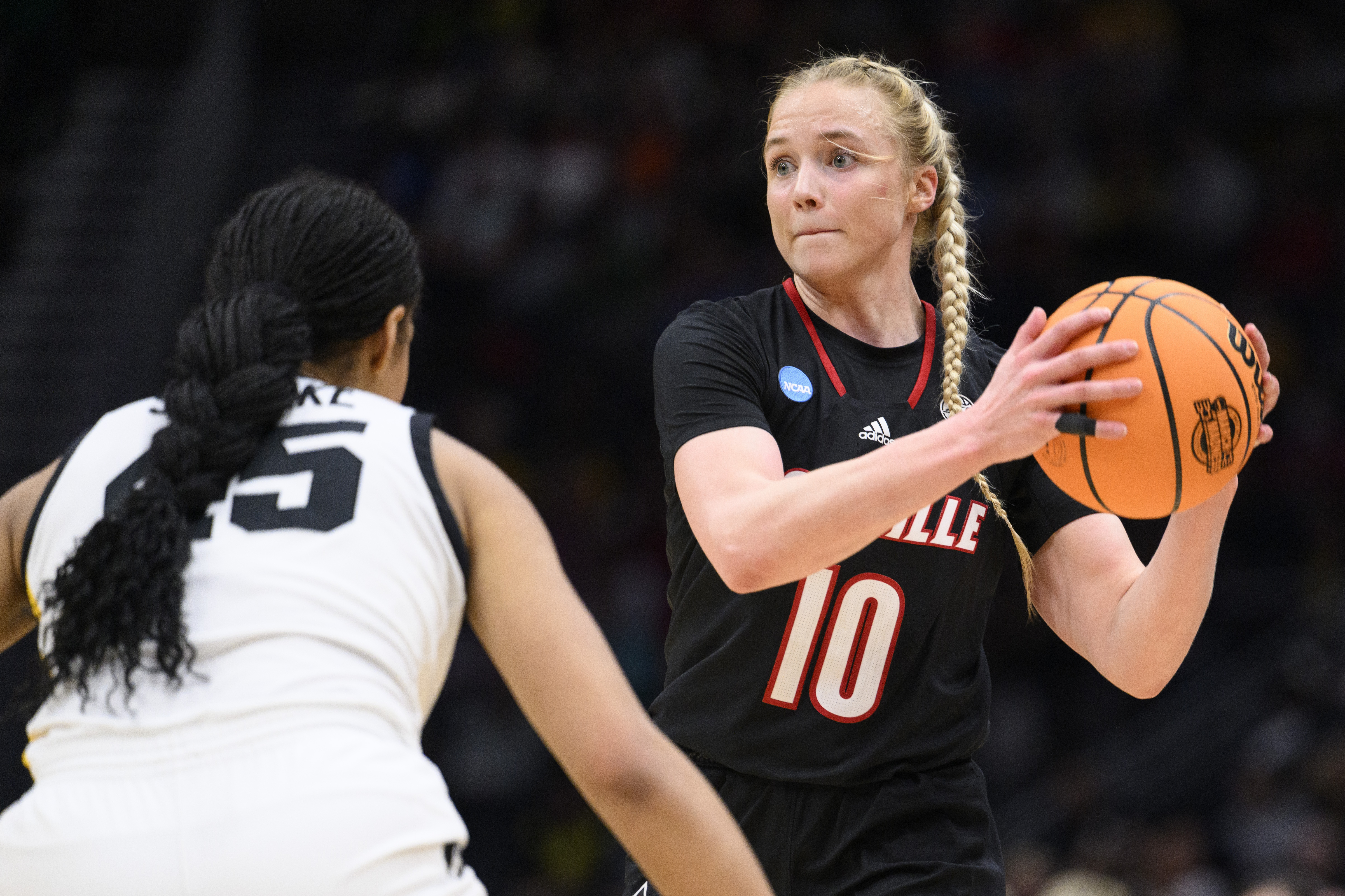 Louisville guard Hailey Van Lith (10) looks for a pass as Iowa forward Hannah Stuelke defends in the second half of an Elite 8 college basketball game of the NCAA Tournament, Sunday, March 26, 2023, in Seattle. (AP Photo/Caean Couto)