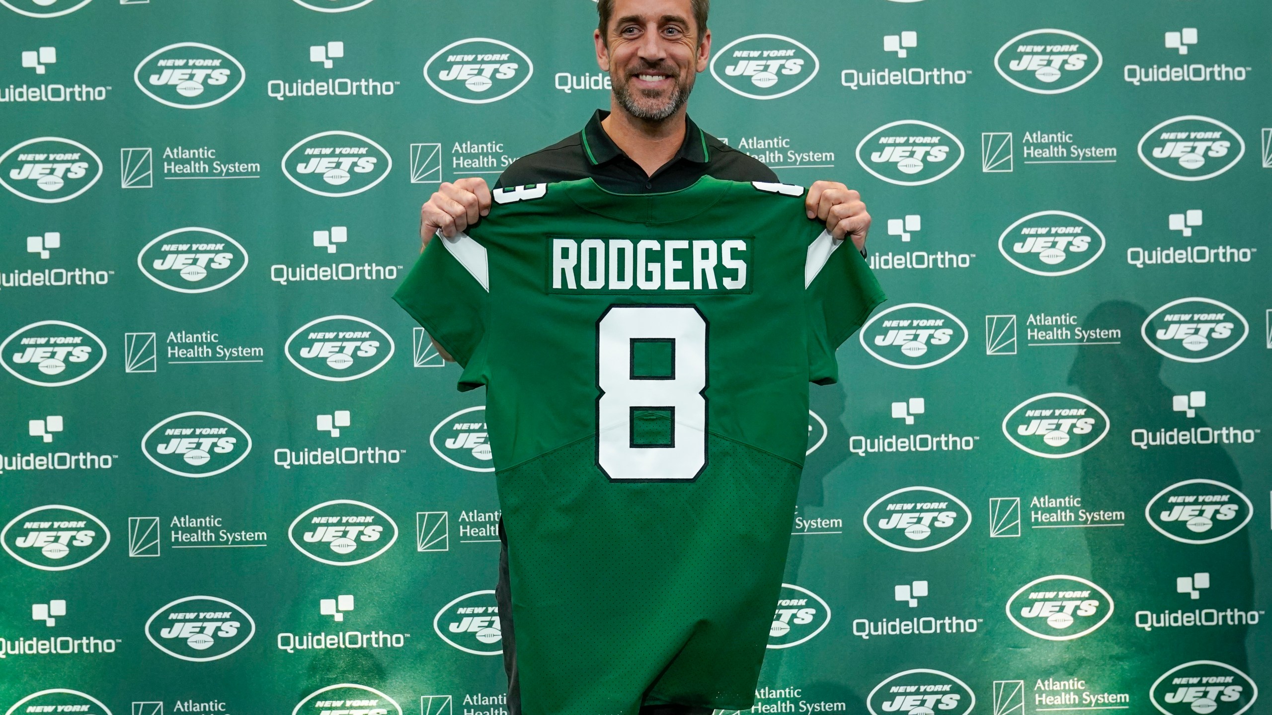 New York Jets' quarterback Aaron Rodgers poses with a jersey after a news conference at the NFL football team's training facility in Florham Park, N.J., Wednesday, April 26, 2023. (AP Photo/Seth Wenig)