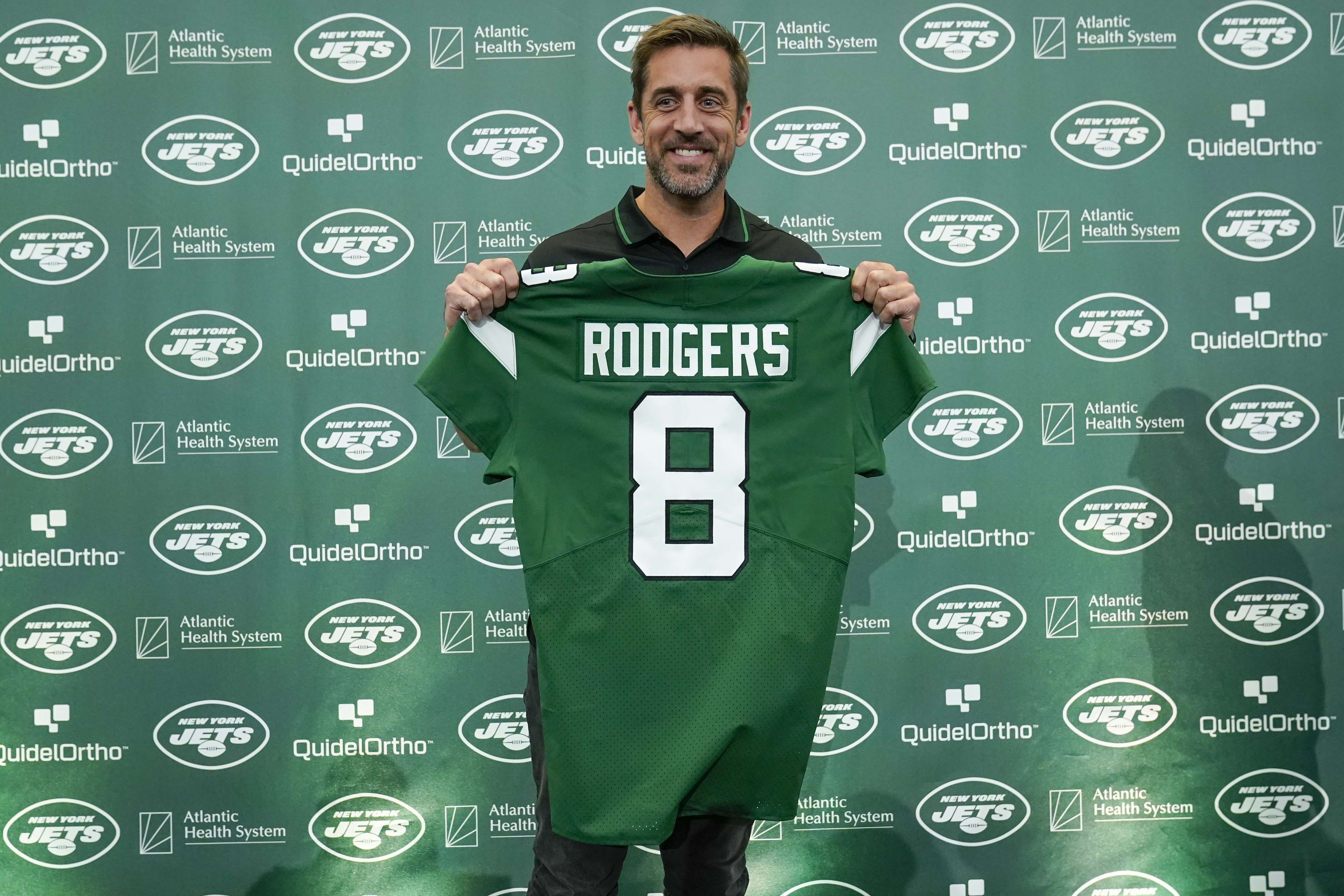 New York Jets' quarterback Aaron Rodgers poses with a jersey after a news conference at the NFL football team's training facility in Florham Park, N.J., Wednesday, April 26, 2023. (AP Photo/Seth Wenig)