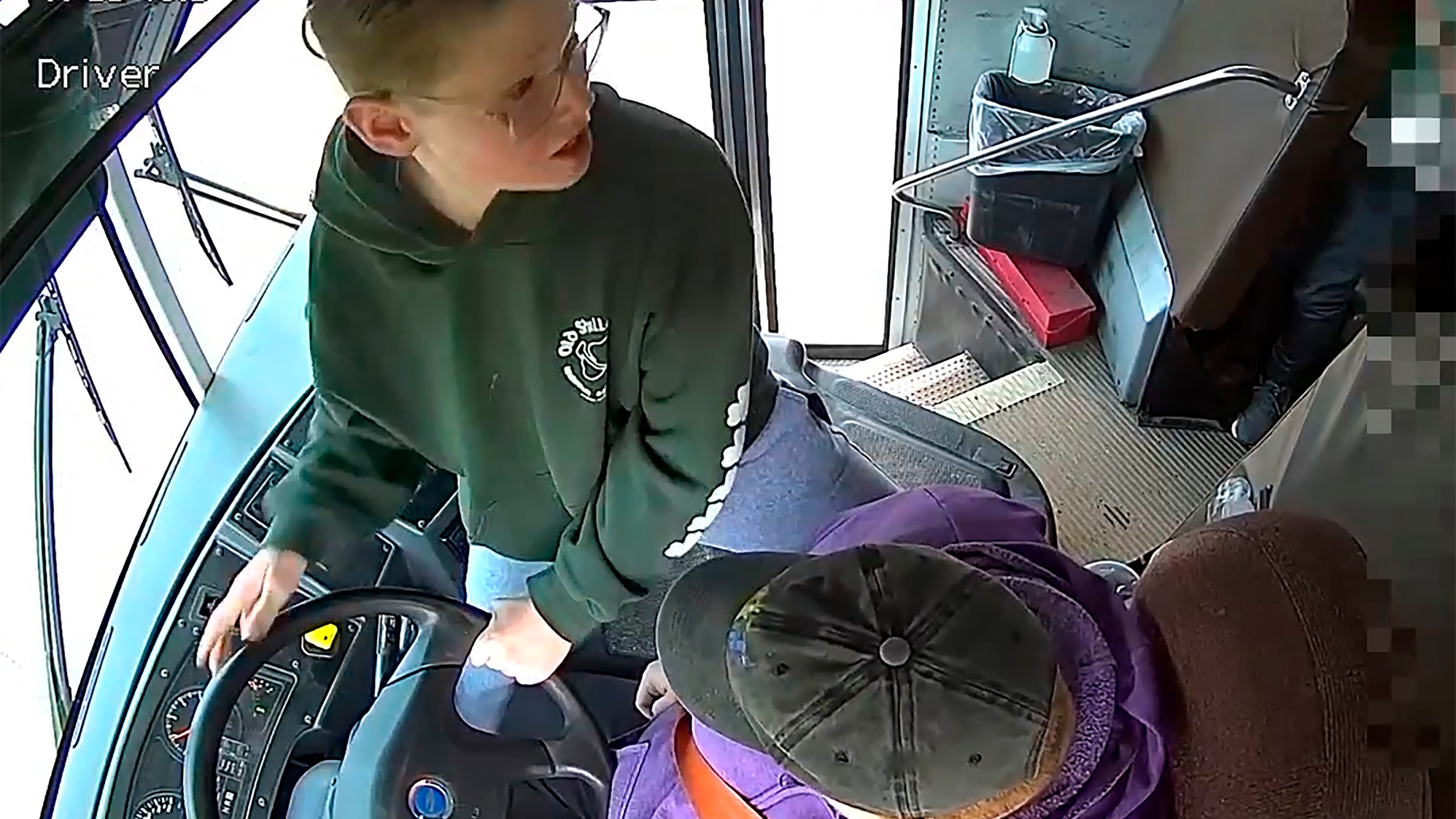 In this image made from video, seventh-grader Dillon Reeves grabs the steering wheel on his school bus and hit the brakes after the driver passed out Wednesday, April 28, 2023, Warren, Mi. Warren Consolidated Schools Superintendent Robert Livernois is calling it an “extraordinary act of courage.” (Warren Consolidated Schools via AP)