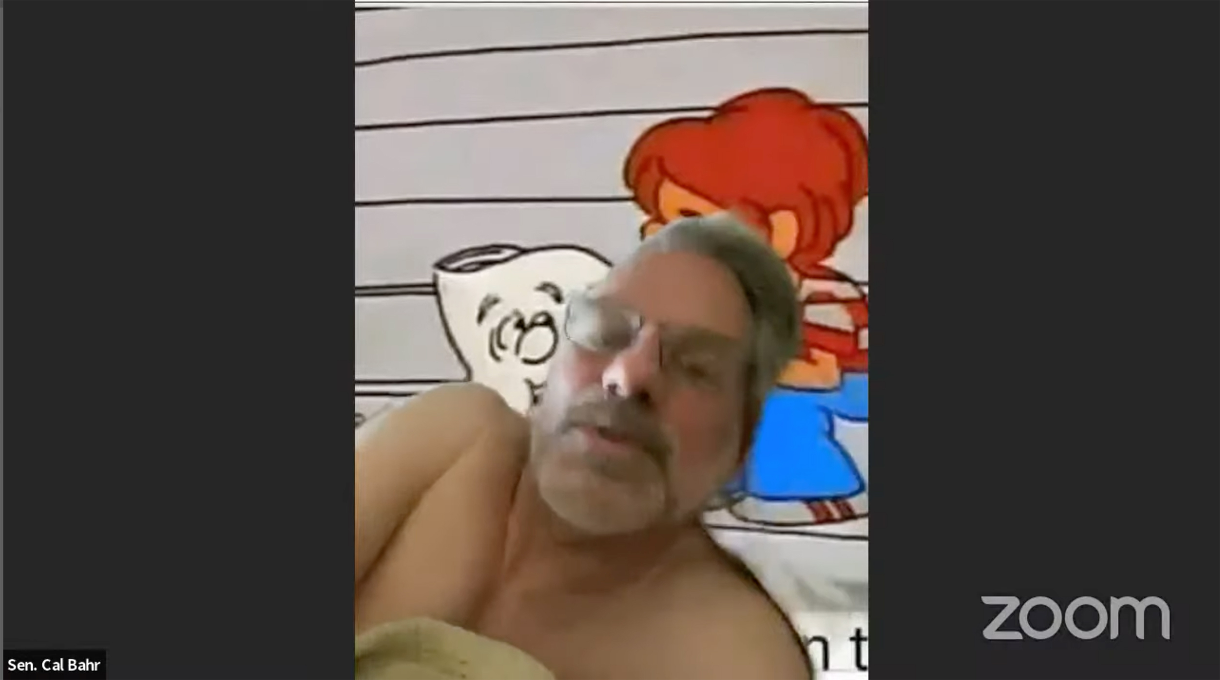 This image taken from Minnesota Office of the Legislative Auditor meeting via Zoom shows Sen. Calvin Bahr shirtless during a vote on Monday, May 1, 2023. In a video streamed on YouTube, Bahr, of East Bethel, can briefly be seen voting — with a School House Rock “I’m Just a Bill” character on the wall behind him — during a Zoom call on Monday with the Legislative Audit Commission. A GOP Senate spokeswoman said Bahr, a truck driver, worked until 4:45 a.m. and then went to bed before Monday's meeting. She said he would not comment on the vote or the video. The Minneapolis Star Tribune reported. ( Minnesota Office of the Legislative Auditor via AP)