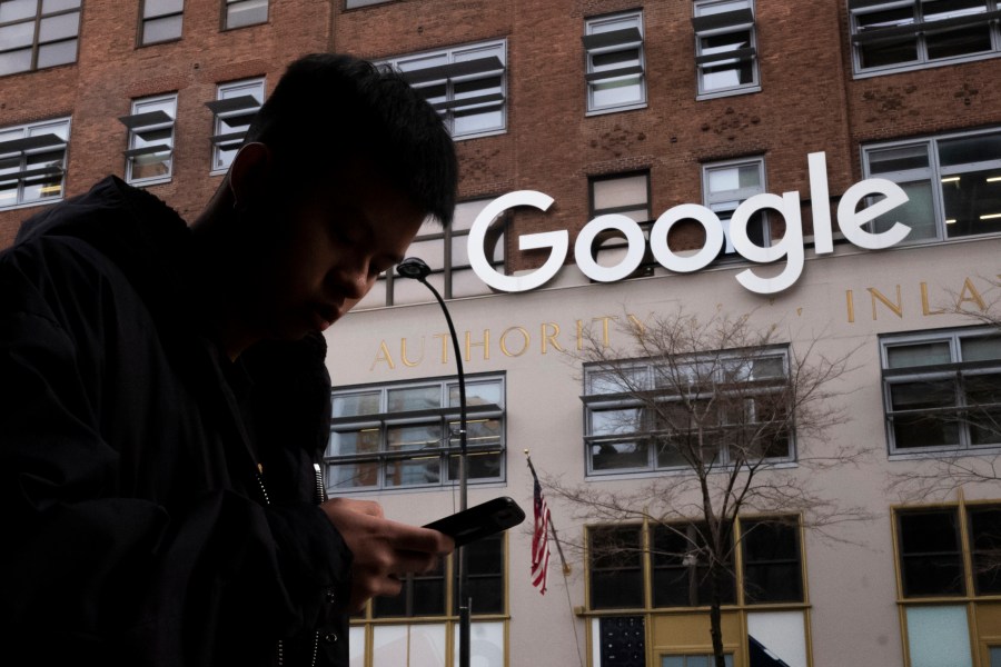 FILE - A man using a cellphone walks past Google offices on Dec. 17, 2018, in New York. On Tuesday, May 9, 2023, Maryland's highest court reversed a ruling by a lower court that the state's first-in-the-nation tax on digital advertising was unconstitutional, saying the court lacked jurisdiction over the case. (AP Photo/Mark Lennihan, File)