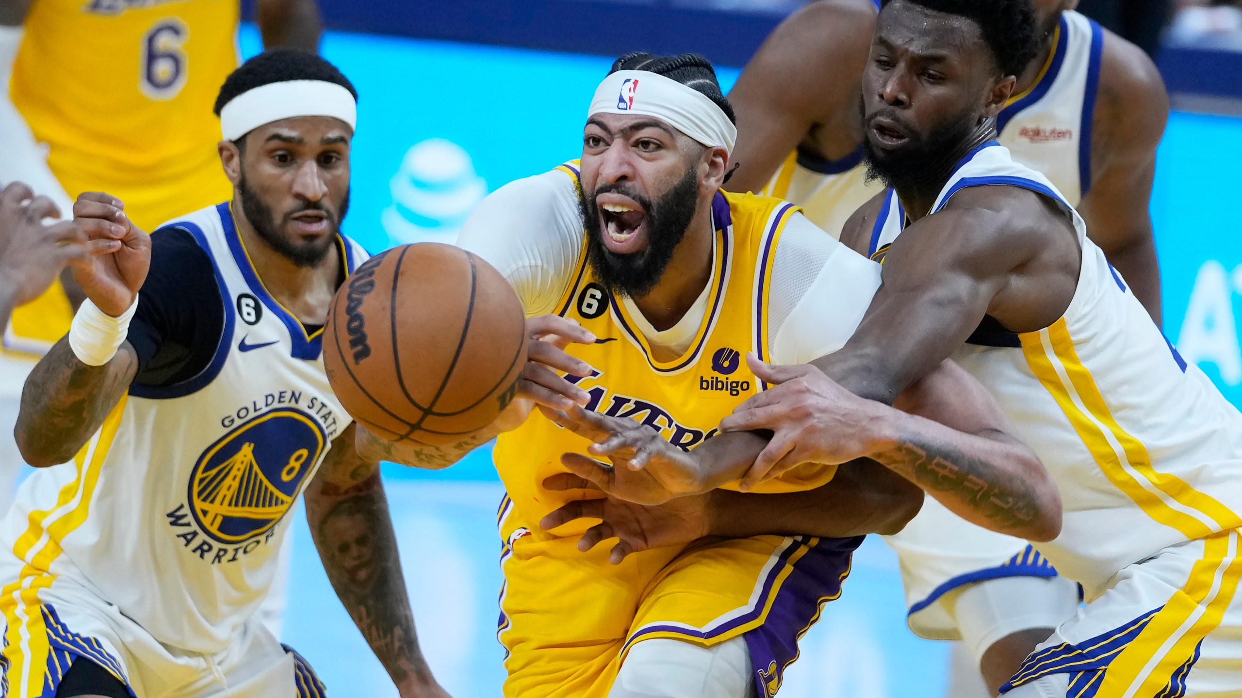 Los Angeles Lakers forward Anthony Davis, middle, reaches for the ball between Golden State Warriors guard Gary Payton II (8) and forward Andrew Wiggins during the first half of Game 5 of an NBA basketball second-round playoff series Wednesday, May 10, 2023, in San Francisco. (AP Photo/Godofredo A. Vásquez)
