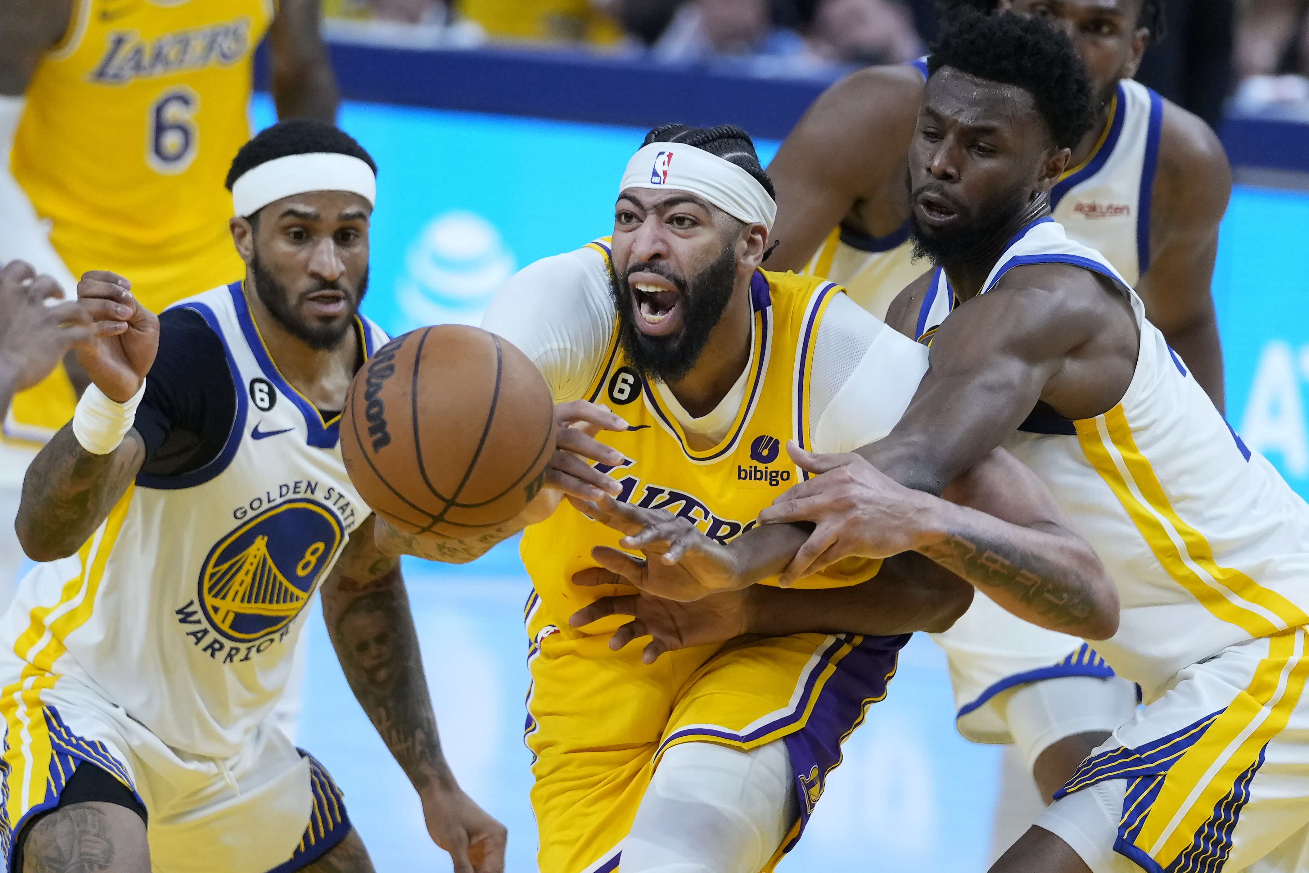 Los Angeles Lakers forward Anthony Davis, middle, reaches for the ball between Golden State Warriors guard Gary Payton II (8) and forward Andrew Wiggins during the first half of Game 5 of an NBA basketball second-round playoff series Wednesday, May 10, 2023, in San Francisco. (AP Photo/Godofredo A. Vásquez)