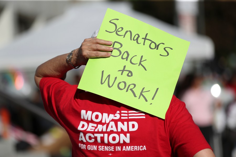 An attendee holds a sign behind their head during a rally calling for an end to the Senate Republican walkout at the Oregon State Capitol in Salem, Ore., Thursday, May 11, 2023. (AP Photo/Amanda Loman)