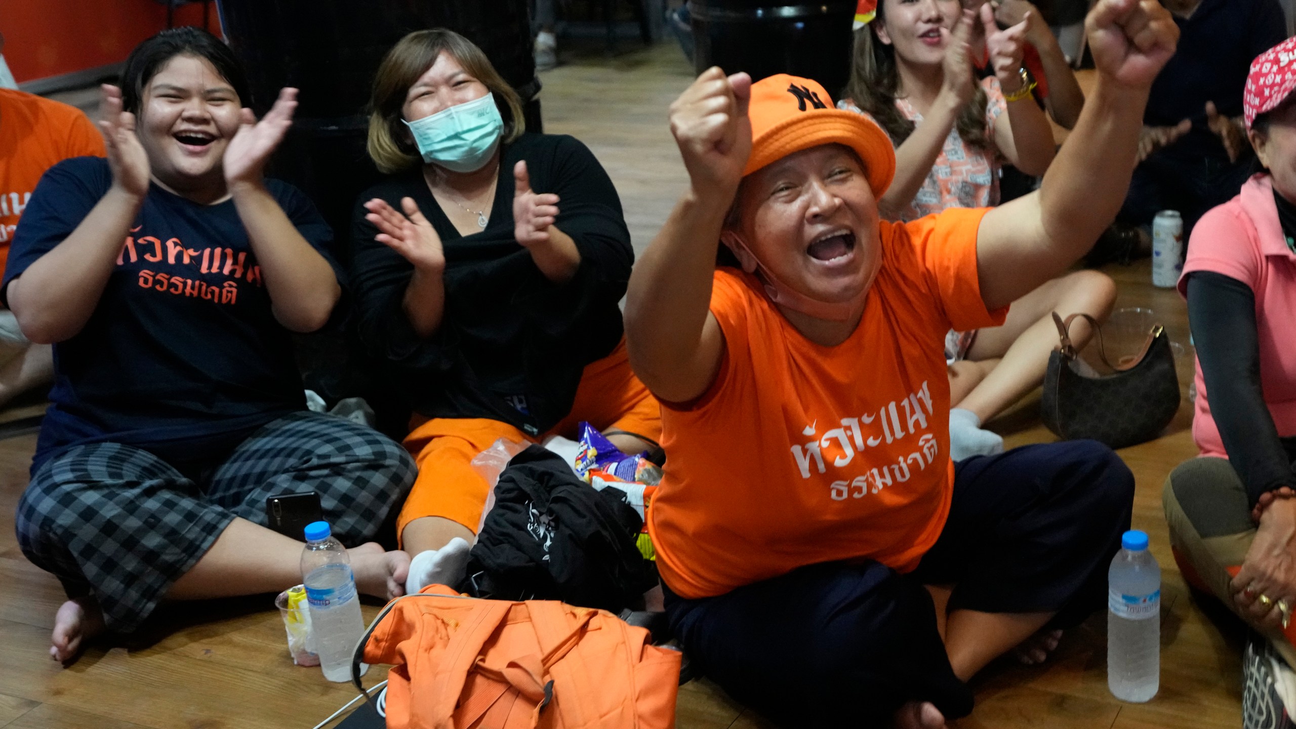 Supporters of Move Forward party cheer as they watch the counting of votes on television at Move Forward Party headquarters in Bangkok, Thailand, Sunday, May 14, 2023. Vote counting was underway Sunday in Thailand's general election, touted as a pivotal chance for change nine years after incumbent Prime Minister Prayuth Chan-ocha first came to power in a 2014 coup. (AP Photo/Sakchai Lalit)