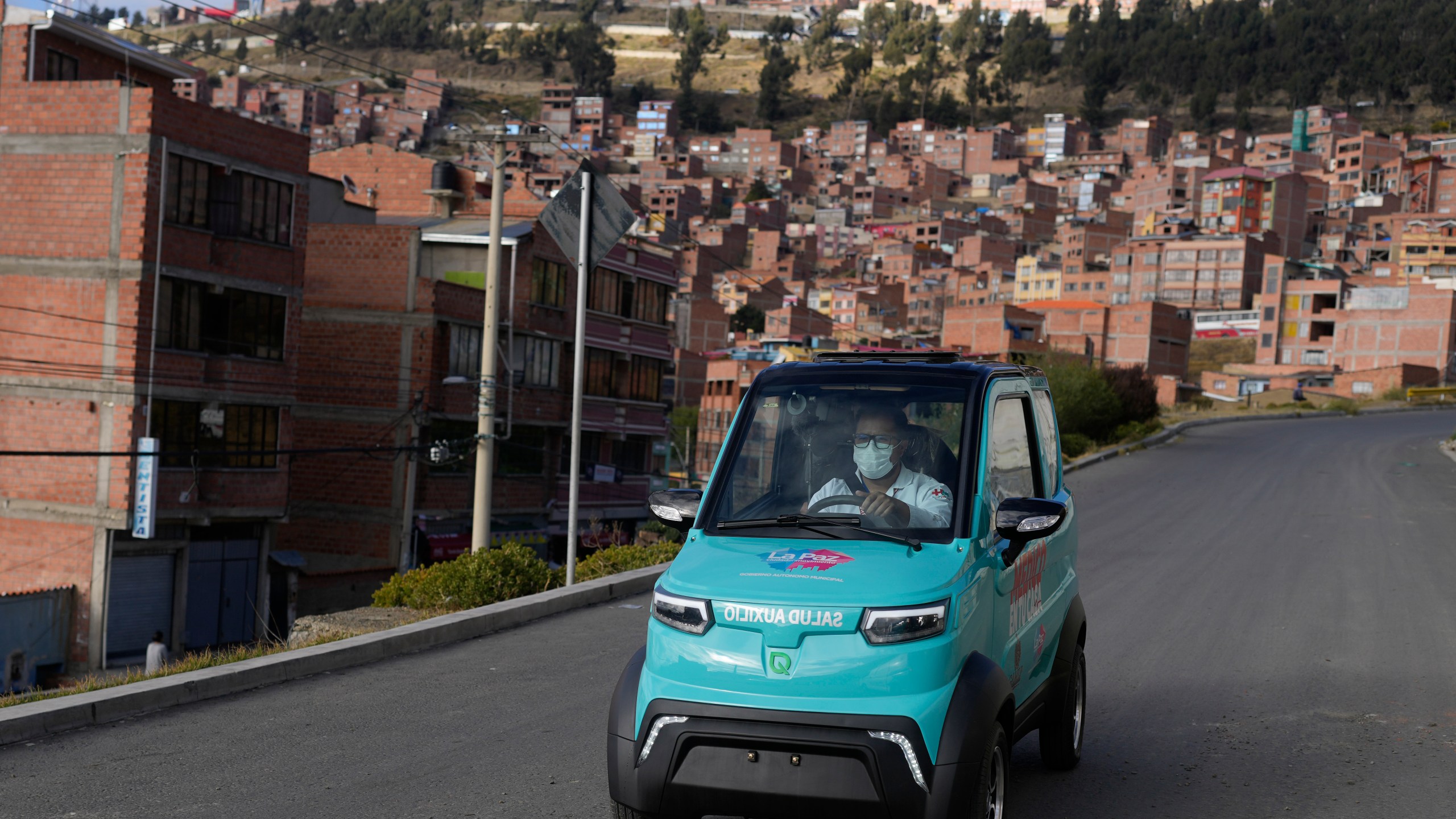 Dr. Carlos Ortuno drives a Bolivian-made, Quantum electric car to a house call, in La Paz, Bolivia, Wednesday, May 3, 2023. Launched in 2019, Quantum Motors has only sold 350 electric cars in Bolivia. But their founders recently received a boost from the German city of Bonn, which invested 50,000 euros to acquire six units in support of a local program that sends doctors to people's homes. (AP Photo/Juan Karita)