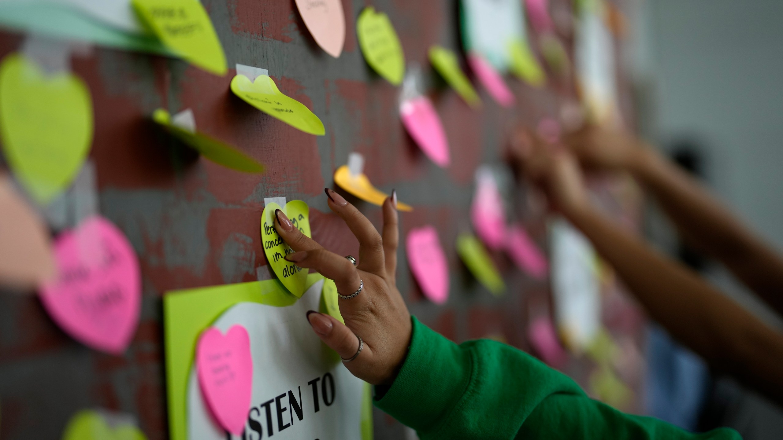 A student adds a note to others expressing support and sharing coping strategies, as members of the Miami Arts Studio mental health club raise awareness on World Mental Health Day, Tuesday, Oct. 10, 2023, at Miami Arts Studio, a public 6th-12th grade magnet school, in Miami. (AP Photo/Rebecca Blackwell)