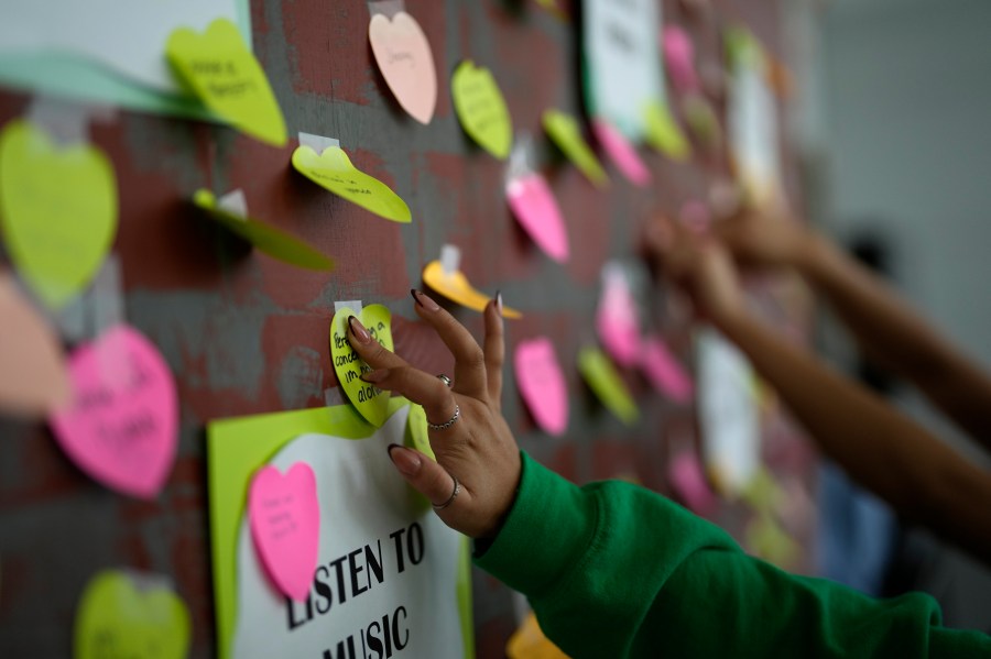 A student adds a note to others expressing support and sharing coping strategies, as members of the Miami Arts Studio mental health club raise awareness on World Mental Health Day, Tuesday, Oct. 10, 2023, at Miami Arts Studio, a public 6th-12th grade magnet school, in Miami. (AP Photo/Rebecca Blackwell)