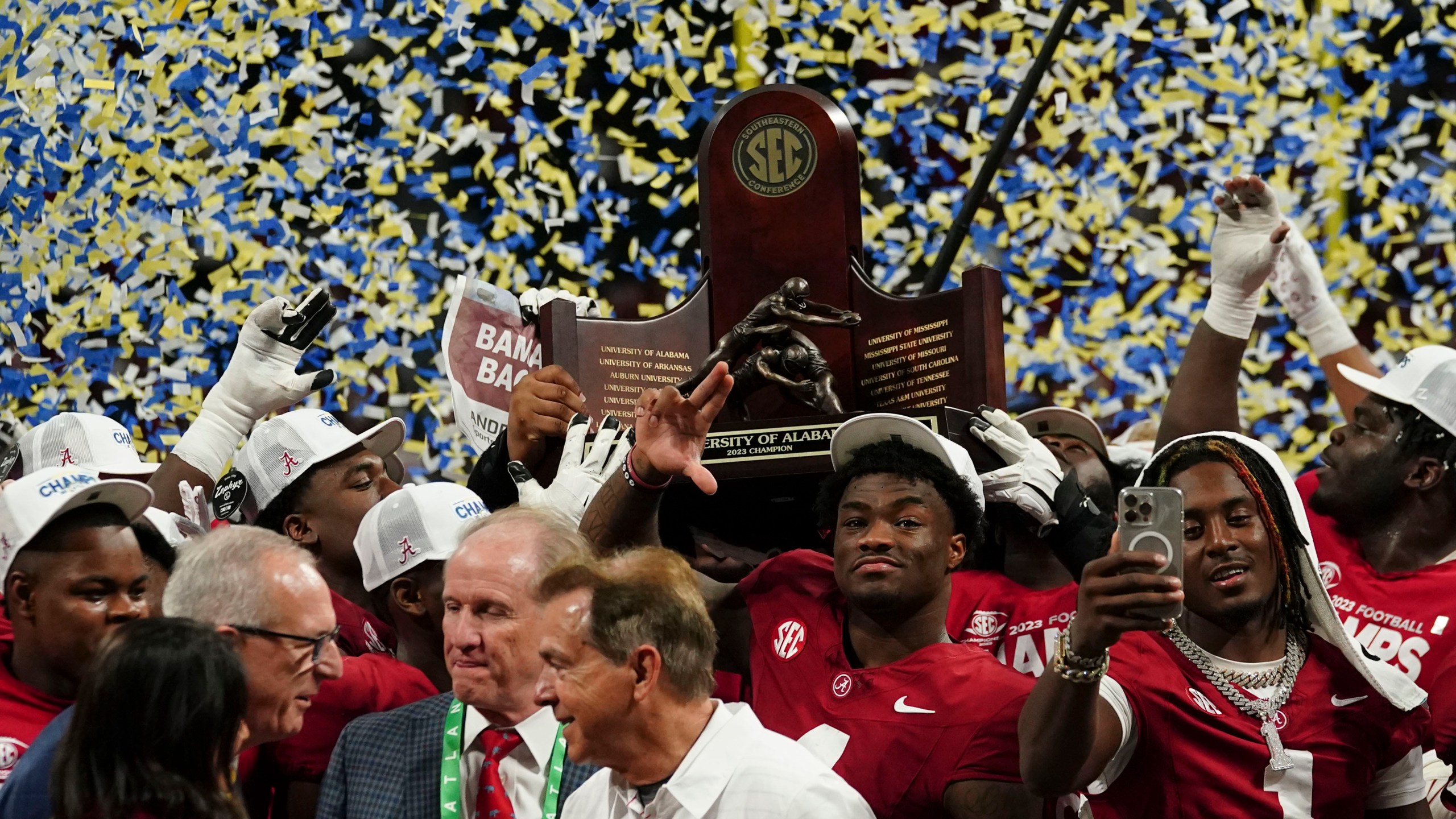 Alabama quarterback Jalen Milroe (4) center and the team holds up the championship trophy after the Southeastern Conference championship NCAA college football game against Georgia in Atlanta, Saturday, Dec. 2, 2023. (AP Photo/John Bazemore)