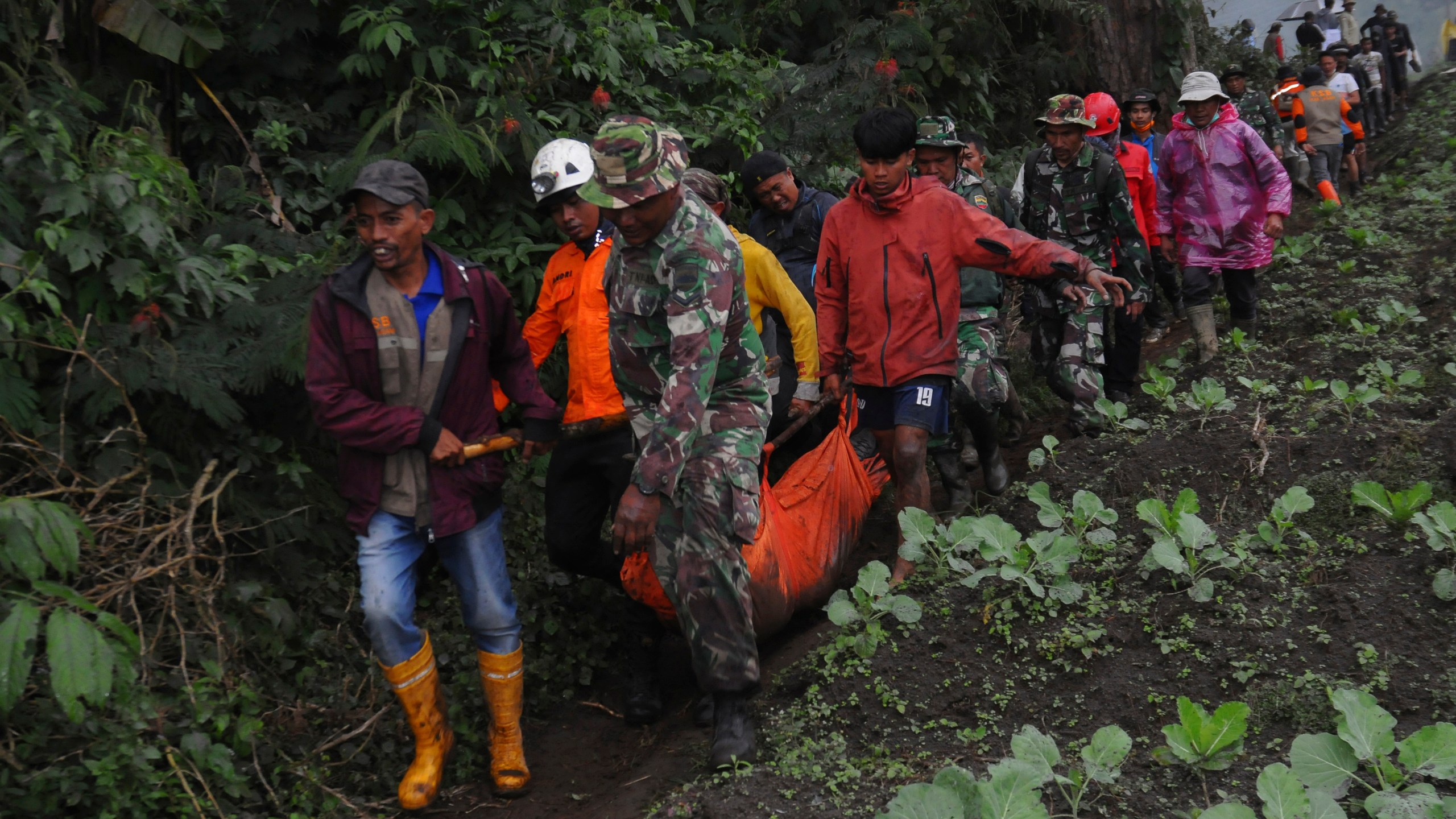 Rescuers carry the body of a victim of the eruption of Mount Marapi in Batu Palano, West Sumatra, Indonesia, Tuesday, Dec. 5, 2023. Rescuers searching the hazardous slopes of the volcano found more bodies of climbers who were caught by a surprise weekend eruption, raising the number of confirmed dead, officials said Tuesday. (AP Photo/Ardhy Fernando)
