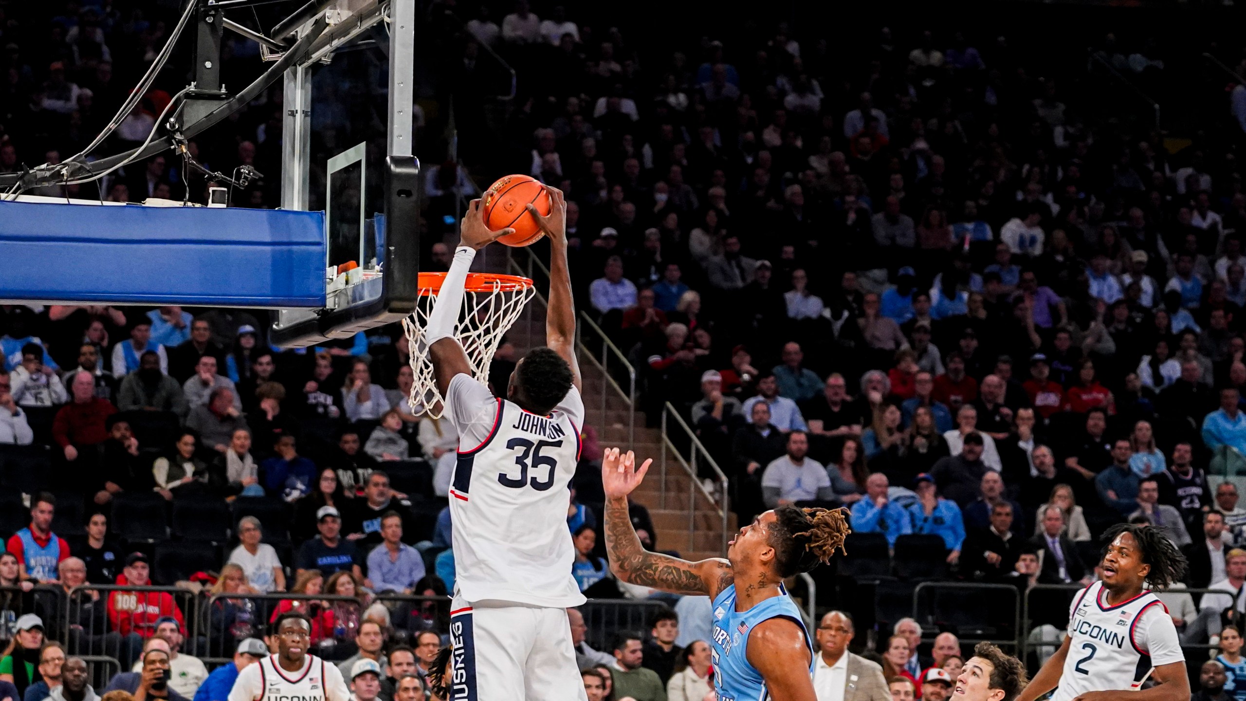 UConn forward Samson Johnson (35) dunks the ball during the first half of an NCAA college basketball game against North Carolina in New York, Tuesday, Dec. 5, 2023. (AP Photo/Peter K. Afriyie)