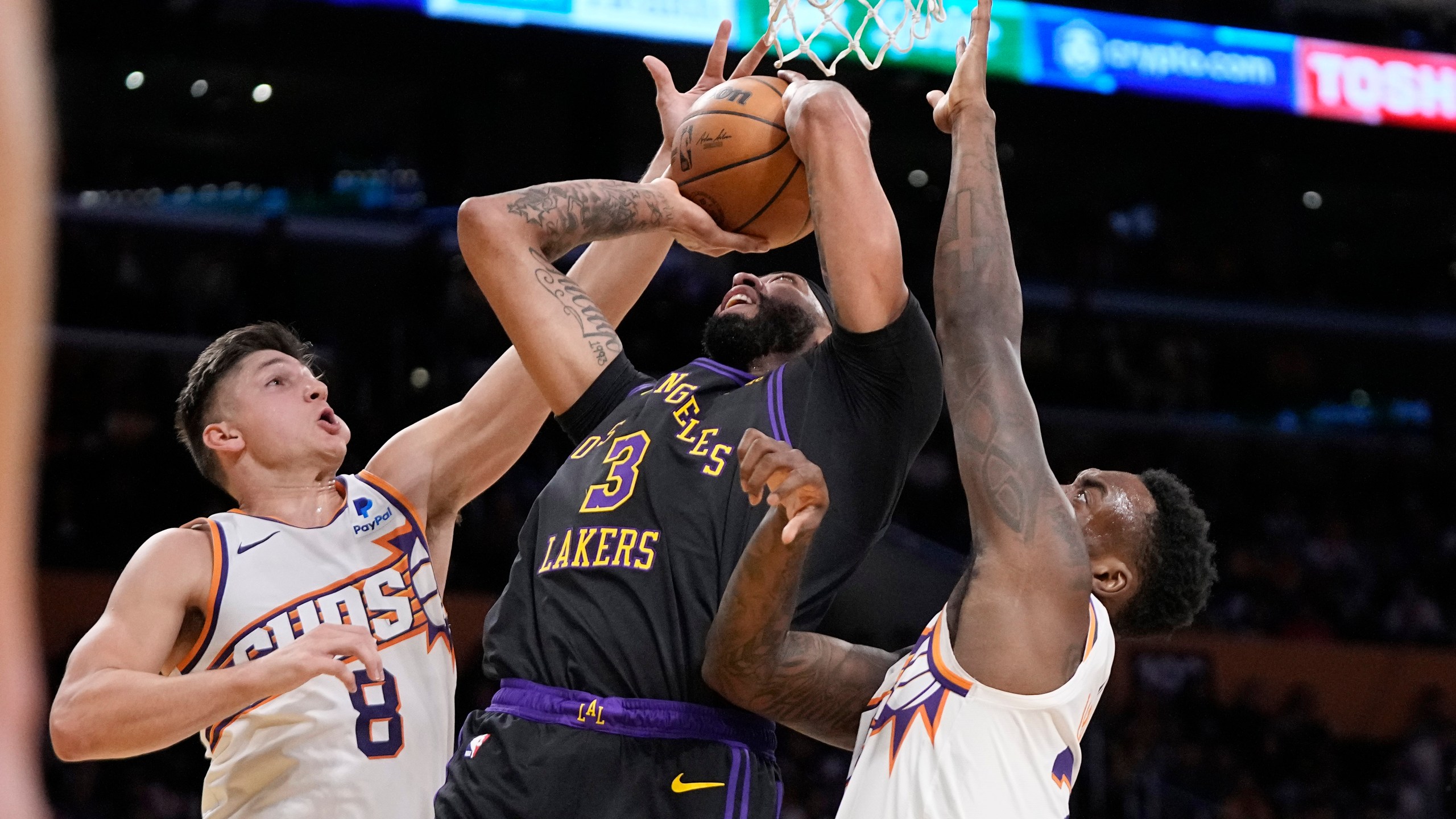 Los Angeles Lakers forward Anthony Davis, center, shoots as Phoenix Suns guard Grayson Allen, left, and forward Nassir Little defend during the first half of an NBA basketball In-Season Tournament quarterfinal game Tuesday, Dec. 5, 2023, in Los Angeles. (AP Photo/Mark J. Terrill)