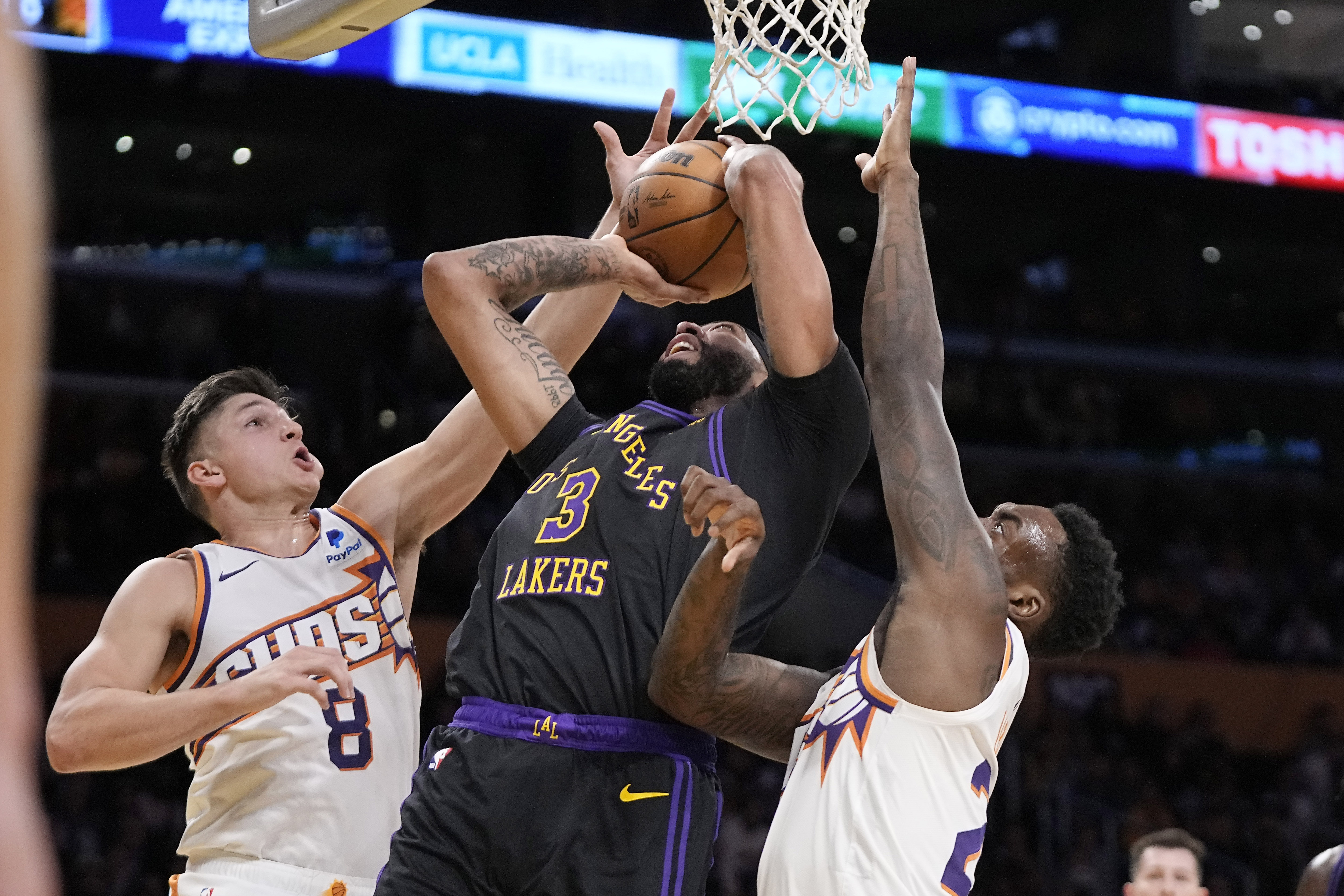 Los Angeles Lakers forward Anthony Davis, center, shoots as Phoenix Suns guard Grayson Allen, left, and forward Nassir Little defend during the first half of an NBA basketball In-Season Tournament quarterfinal game Tuesday, Dec. 5, 2023, in Los Angeles. (AP Photo/Mark J. Terrill)