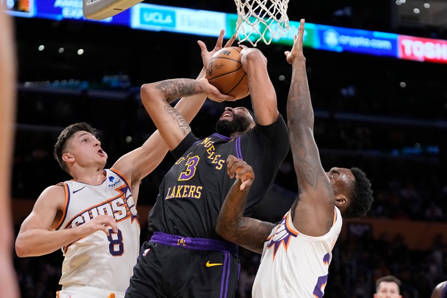 Los Angeles Lakers forward Anthony Davis, center, shoots as Phoenix Suns guard Grayson Allen, left, and forward Nassir Little defend during the first half of an NBA basketball In-Season Tournament quarterfinal game Tuesday, Dec. 5, 2023, in Los Angeles. (AP Photo/Mark J. Terrill)