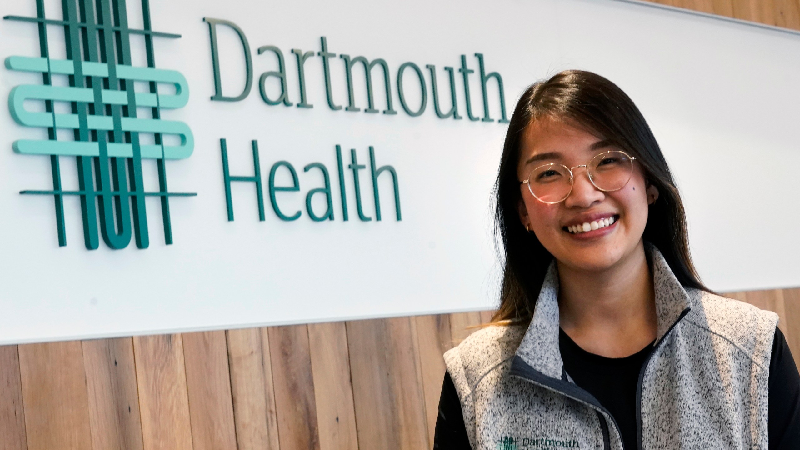 Andy Hoang, a recent nursing graduate, poses at the Dartmouth-Hitchcock Medical Center, Tuesday, Dec. 5, 2023, in Lebanon, N.H. Hoang, 23, started to feel dizzy and nauseous during a cardiac training session at the hospital and needed help immediately. Instead of practicing chest compressions on a mannequin in the simulated environment of their training, her four colleagues sprung into action and went to work on her. (AP Photo/Charles Krupa)