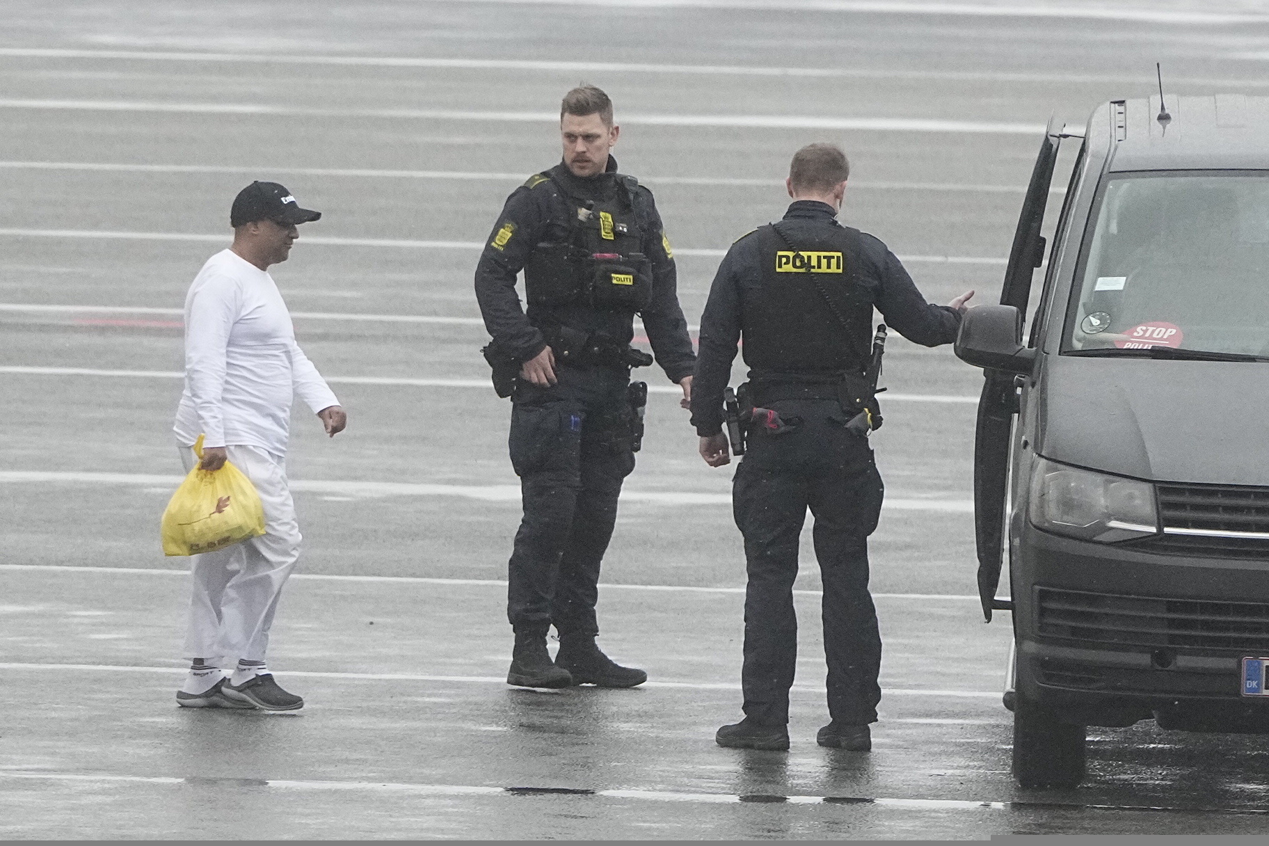 Danish police officers accompany financier Sanjay Shah as he arrives at Kastrup Airport, in Copenhagen, Wednesday, Dec. 6, 2023. Shah, a Dubai-based British hedge fund trader sought by Danish authorities for allegedly orchestrating a $1.7 billion tax fraud, considered one of the largest in the Scandinavian country, has been extradited from the United Arab Emirates, officials said Wednesday. (Mads Claus Rasmussen/Ritzau Scanpix via AP)