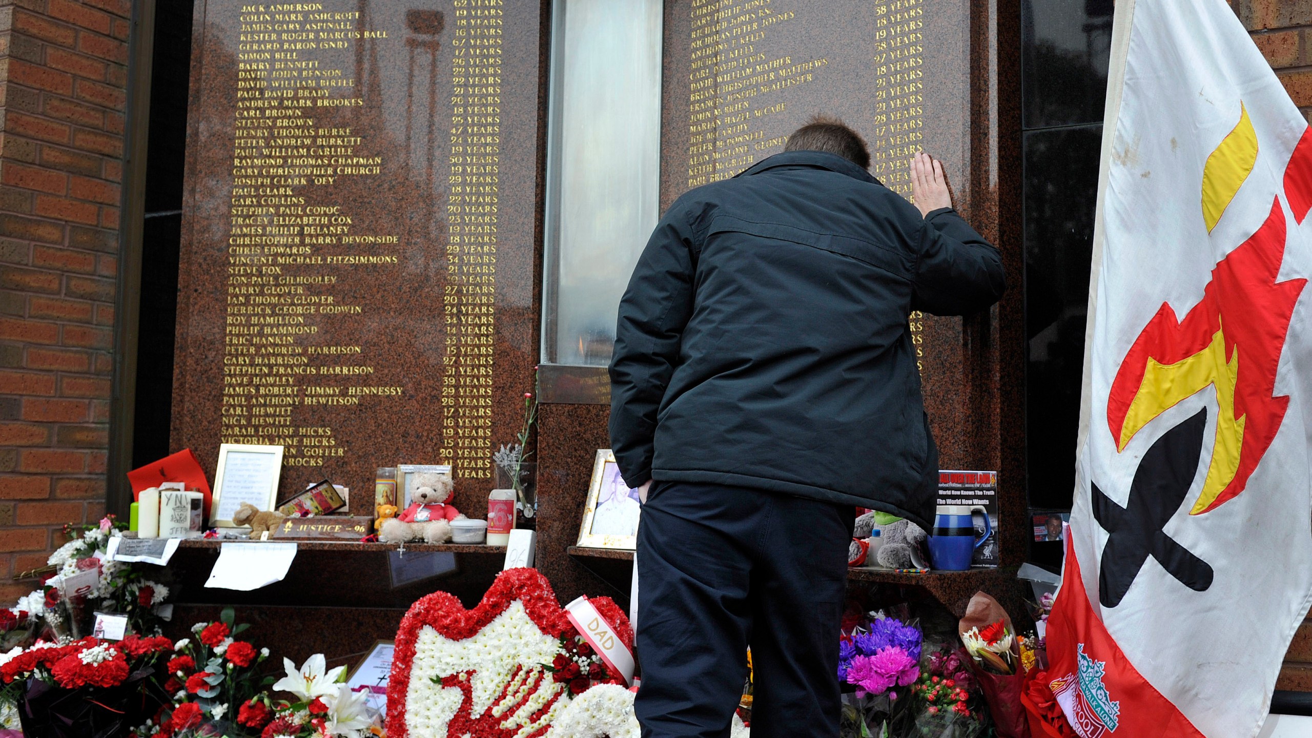 FILE - A Liverpool fan pays his respects to the fans who died in the 1989 Hillsborough Stadium tragedy outside the Anfield Hillsborough memorial ahead of an English Premier League soccer match at Anfield in Liverpool, England, Sunday Sept. 23, 2012. The British government apologized Wednesday, Dec. 6, 2023 to the families of 97 Liverpool soccer fans who died after a stadium crush 34 years ago, as it introduced a charter it said will sharply diminish the chances that others will endure the kinds of injustices they suffered. (AP Photo/Clint Hughes, file)