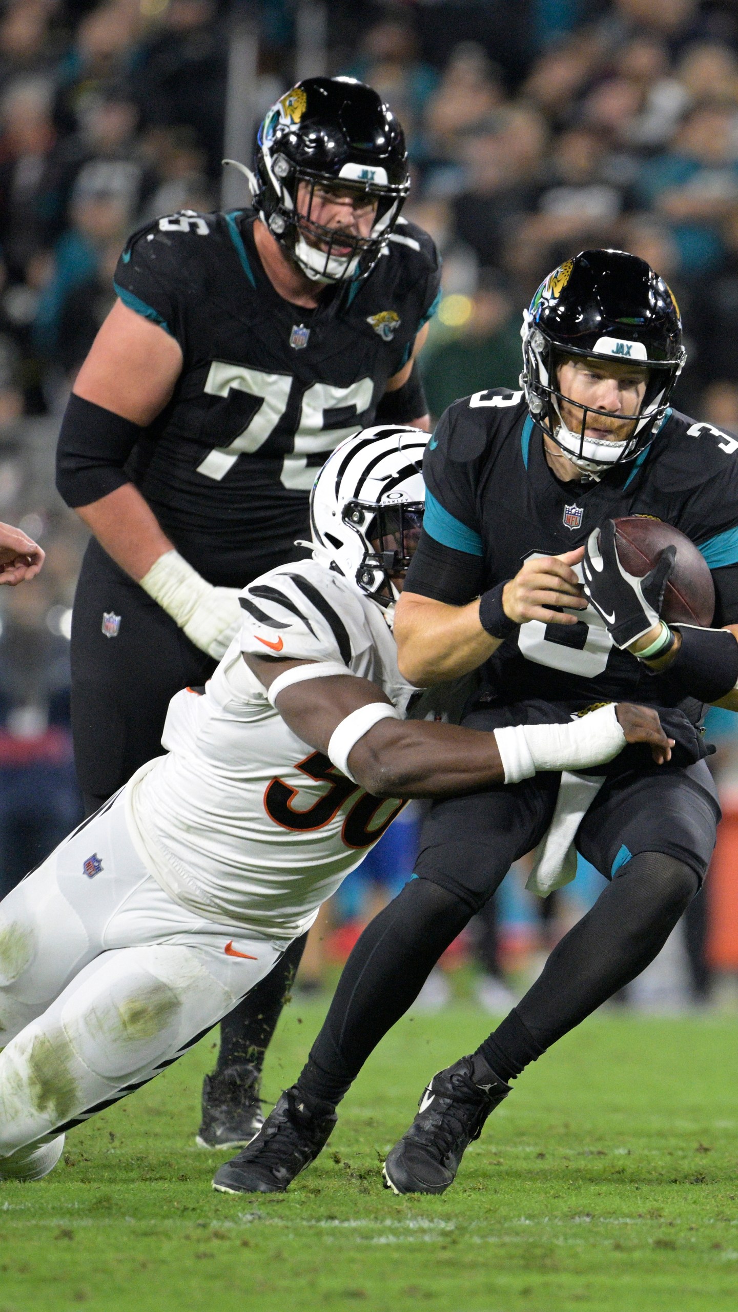 Jacksonville Jaguars quarterback C.J. Beathard (3) is tackled by Cincinnati Bengals defensive end Joseph Ossai (58) during the second half of an NFL football game, Monday, Dec. 4, 2023, in Jacksonville, Fla. (AP Photo/Phelan M. Ebenhack)