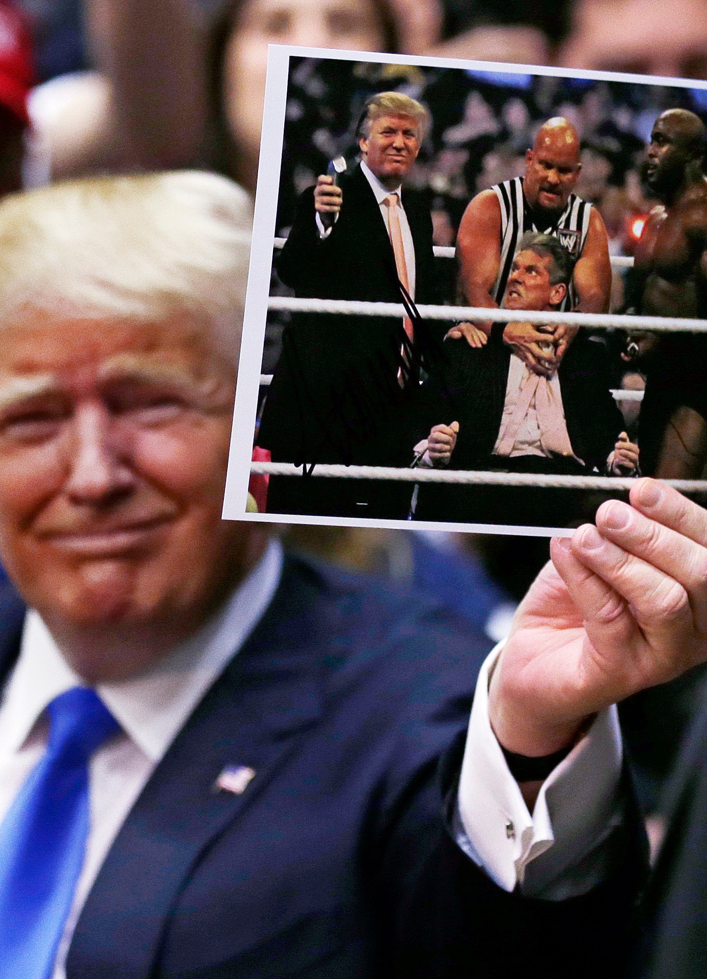 FILE - Republican presidential candidate Donald Trump holds up a photograph of him participating in WrestleMania during a campaign event at Crosby High School in Waterbury, Conn., Saturday, April 23, 2016. (AP Photo/Charles Krupa, File)