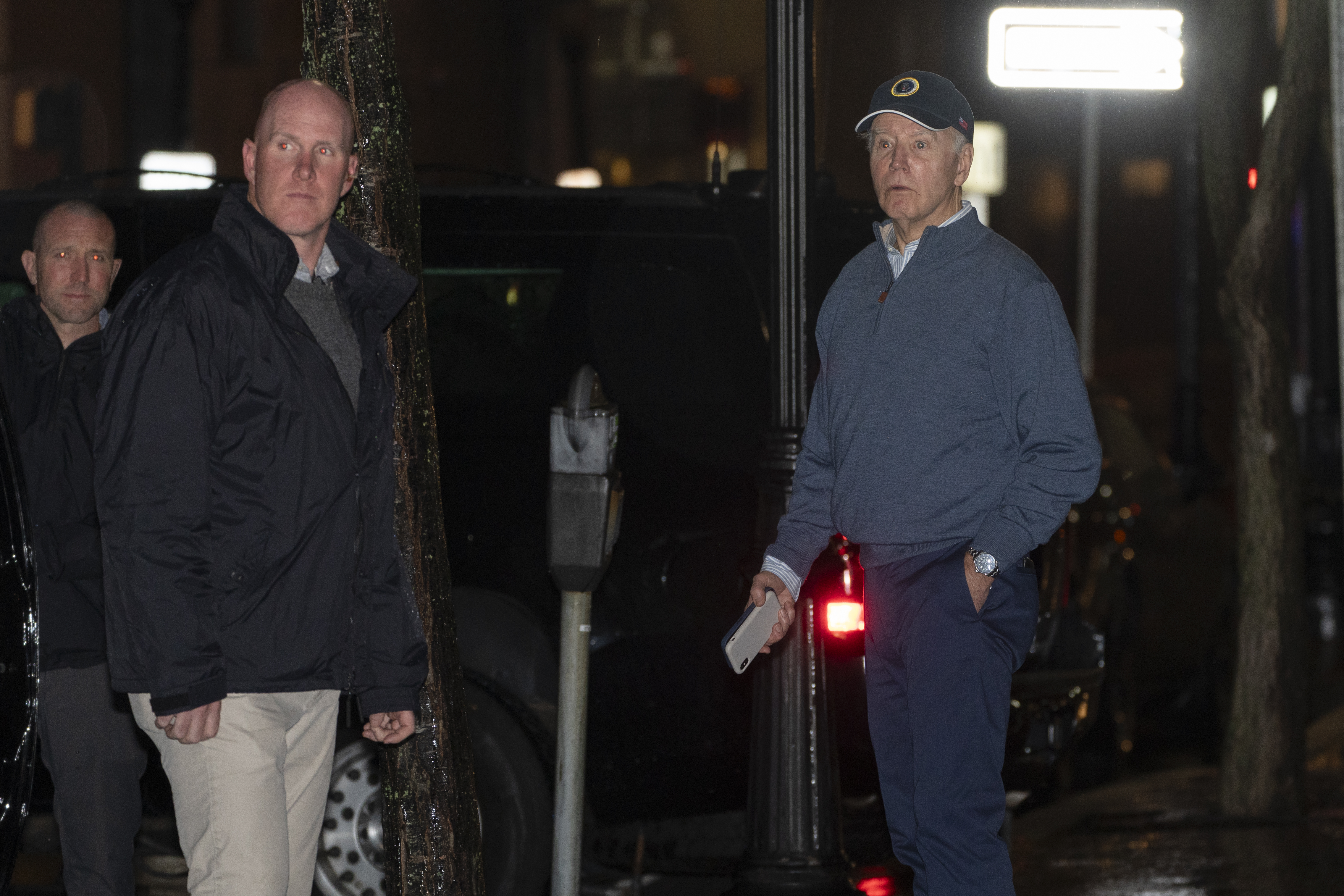 President Joe Biden reacts after hearing a loud bang as he leaves his campaign headquarters in Wilmington, Del., Sunday, Dec. 17, 2023. A car plowed into a parked SUV that was part of Biden's motorcade Sunday night while the president was leaving a visit to his campaign headquarters. The president and first lady Jill Biden were unharmed. (AP Photo/Manuel Balce Ceneta)